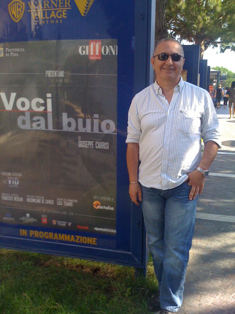 Giuseppe Carrisi accanto alla locandina del suo film  Voci dal buio - al Warner Village Parco dé Medici a Roma